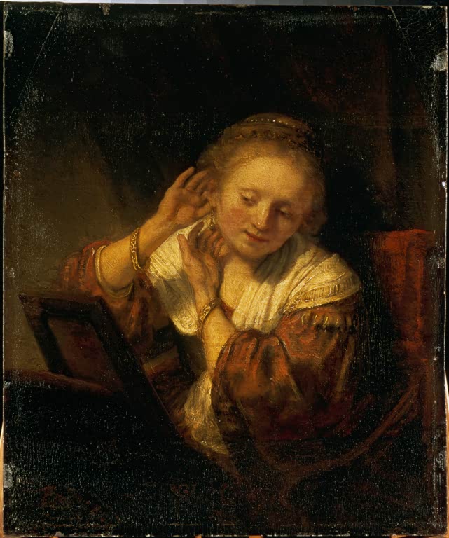 Junge Frau, sich mit Ohrringen schmückend | Rembrandt van Rijn