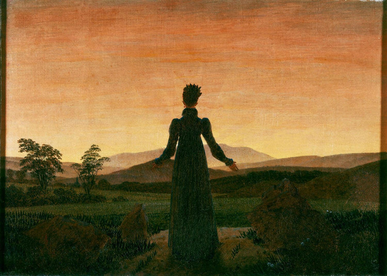 Rückansicht einer Frau im langen Kleid, die im Abendlicht in eine weite Landschaft blickt. Frau vor der untergehenden Sonne | Caspar David Friedrich