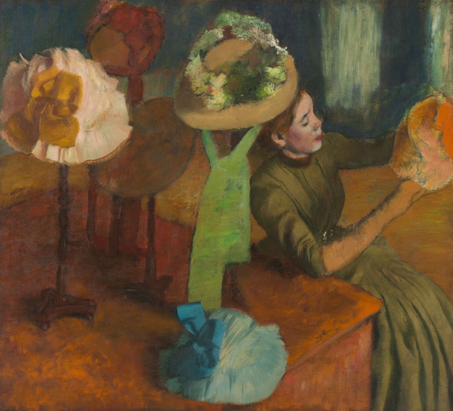 Das Gemälde „Der Hutmacherladen“ von Edgar Degas zeigt eine junge Frau, die in einem Hutgeschäft einen Hut betrachtet. Sie hält den Hut vorsichtig in ihren Händen, während sie in einer leicht schrägen Perspektive dargestellt wird. Um sie herum sind unvollständige Hüte auf einem Tisch ausgestellt. Die Szene vermittelt den Eindruck eines flüchtigen Blicks auf das Alltagsleben im Paris des 19. Jahrhunderts, mit einem besonderen Fokus auf die Dynamik und Details der Modewelt.