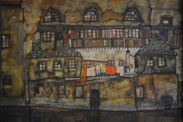 Hausfassade mit Rundbogenfenstern und bunter Wäsche am Fluss – Egon Schiele Hausmauer am Fluss Kunstkopie