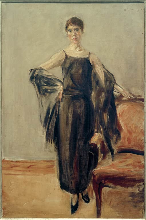 Junge Frau im schwarzen Kleid mit Schal steht neben einem roten Sessel – Max Liebermann Genia Levine, stehend Kunstkopie