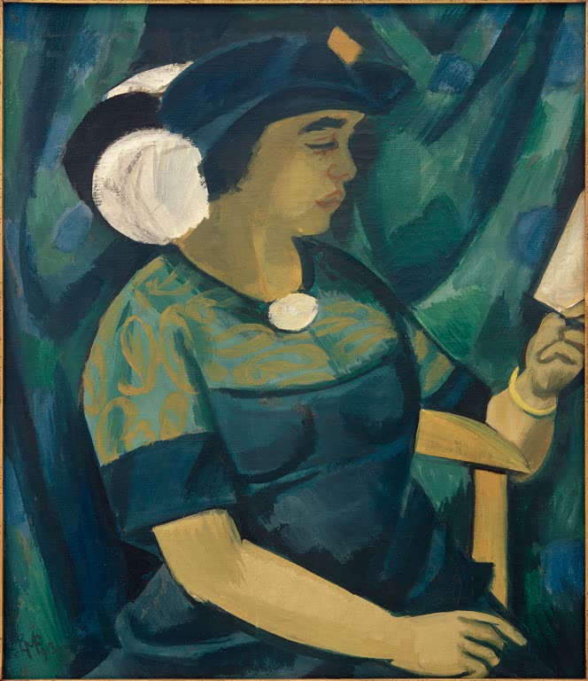 Frau mit Hut liest im Stuhl, blaugrünes Kleid vor dunklem Vorhang – Max Pechstein Bildnis der Frau des Künstlers Kunstkopie