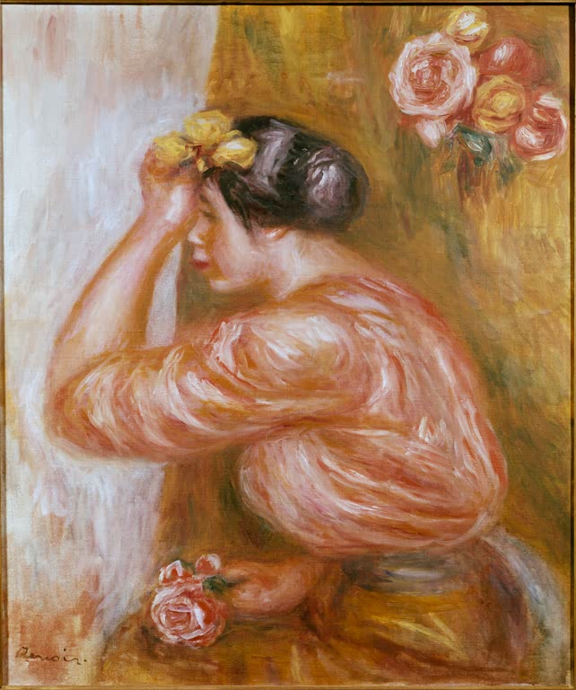 Frau in rosa Bluse ordnet ihr Haar, daneben Rosen – Pierre-Auguste Renoir Mädchen mit Rosen vor dem Spiegel Kunstkopie